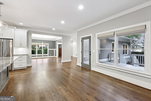 unfurnished living room with baseboards, visible vents, dark wood finished floors, recessed lighting, and ornamental molding