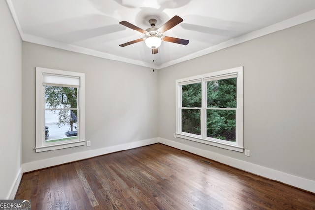 empty room featuring visible vents, crown molding, baseboards, wood finished floors, and a ceiling fan