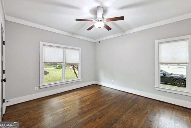 unfurnished room featuring dark wood-style floors, visible vents, crown molding, and baseboards