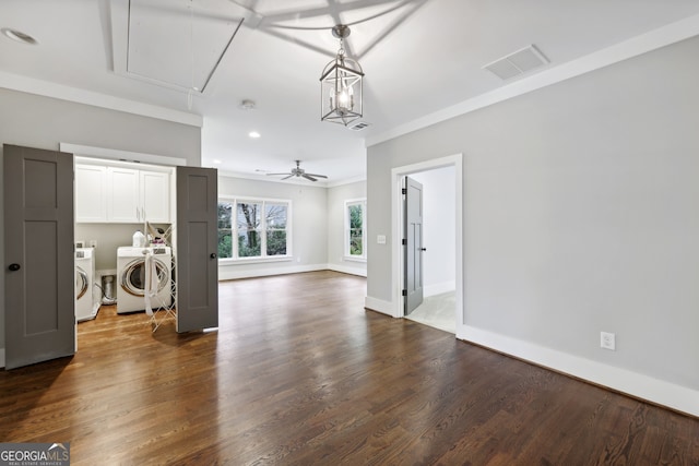 unfurnished living room with visible vents, baseboards, dark wood finished floors, attic access, and washer and dryer