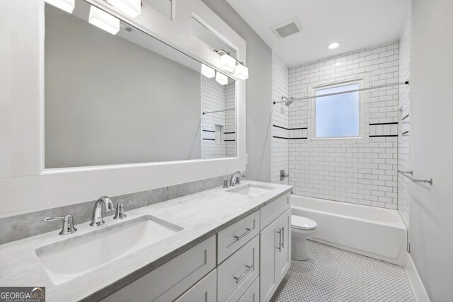 full bathroom with visible vents, toilet, bathing tub / shower combination, and a sink