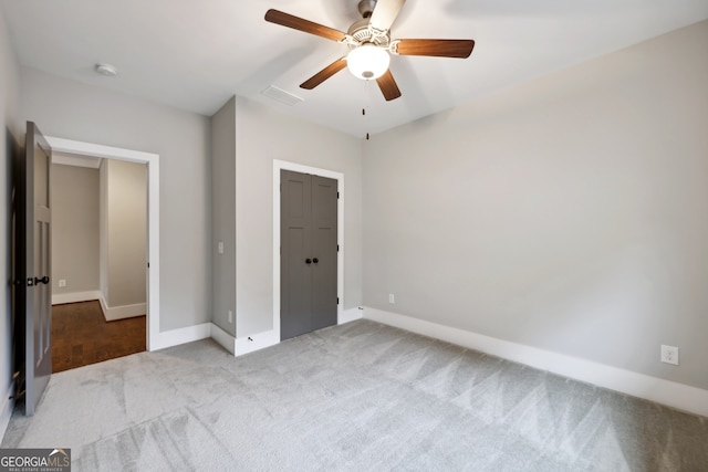 unfurnished bedroom featuring visible vents, a ceiling fan, a closet, carpet flooring, and baseboards