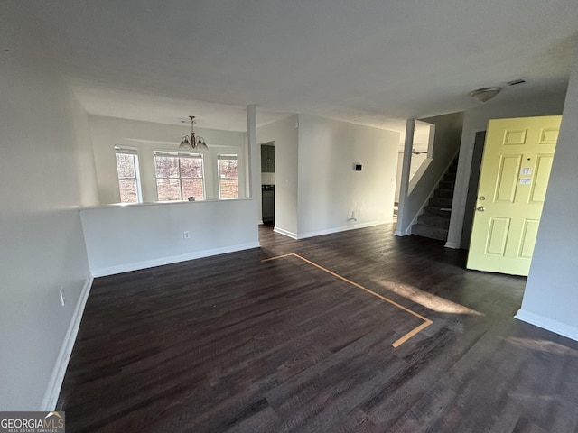 unfurnished living room with baseboards, dark wood-style floors, and stairs