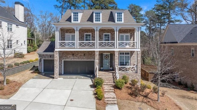 view of front of property featuring an attached garage, a balcony, a porch, and driveway