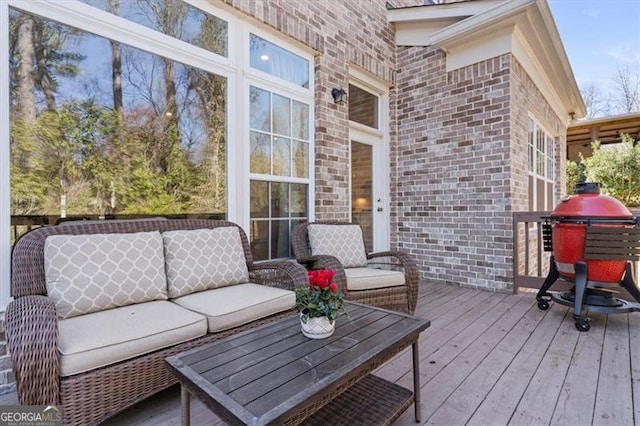 wooden terrace featuring grilling area and an outdoor living space