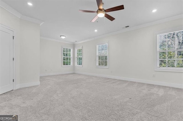 unfurnished room featuring carpet flooring, visible vents, crown molding, and a healthy amount of sunlight