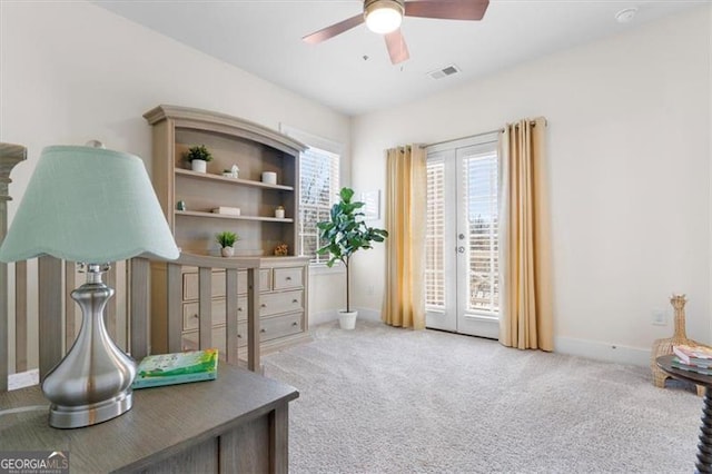 interior space featuring visible vents, light carpet, baseboards, and a ceiling fan