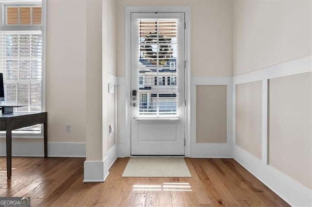 doorway to outside featuring baseboards and wood finished floors