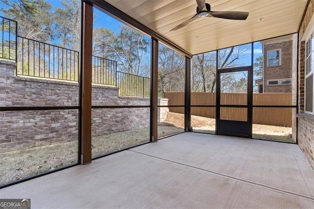 unfurnished sunroom featuring wood ceiling and ceiling fan