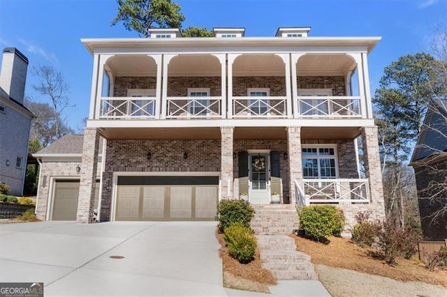 view of front of home featuring a balcony, a porch, concrete driveway, a garage, and brick siding