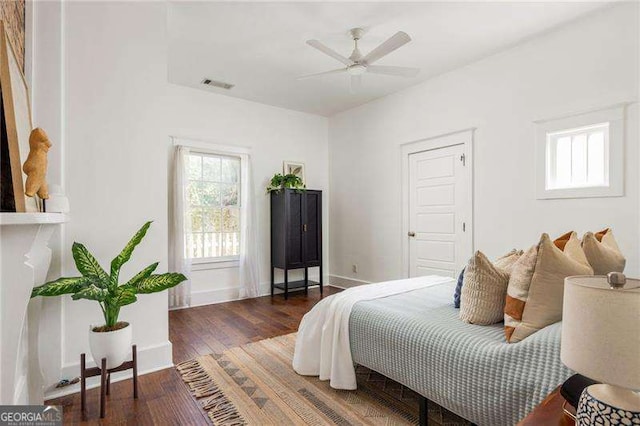 bedroom with visible vents, baseboards, and wood finished floors