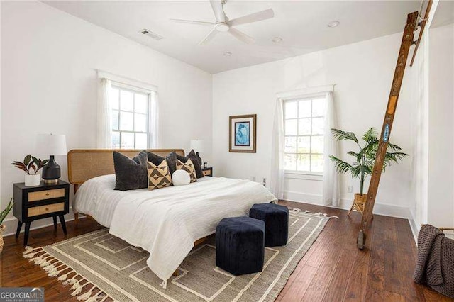 bedroom featuring ceiling fan, wood finished floors, visible vents, and baseboards