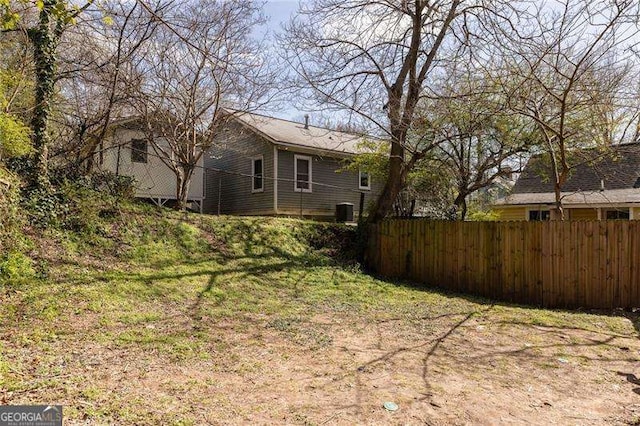 view of yard featuring central AC unit and fence