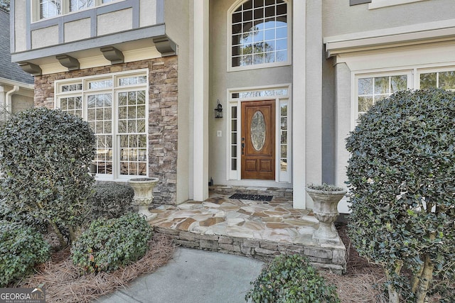 property entrance with stone siding and stucco siding