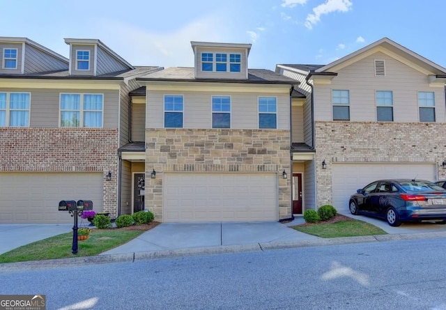 townhome / multi-family property with concrete driveway, an attached garage, and stone siding