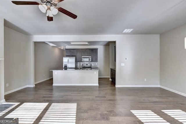 kitchen featuring ceiling fan, dark wood-style floors, backsplash, and stainless steel appliances