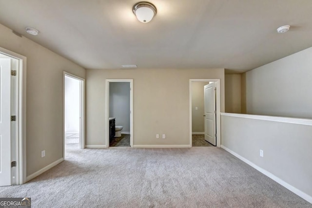 unfurnished bedroom featuring carpet, baseboards, and connected bathroom