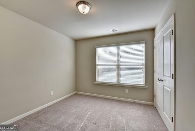 unfurnished room featuring visible vents, baseboards, and carpet flooring