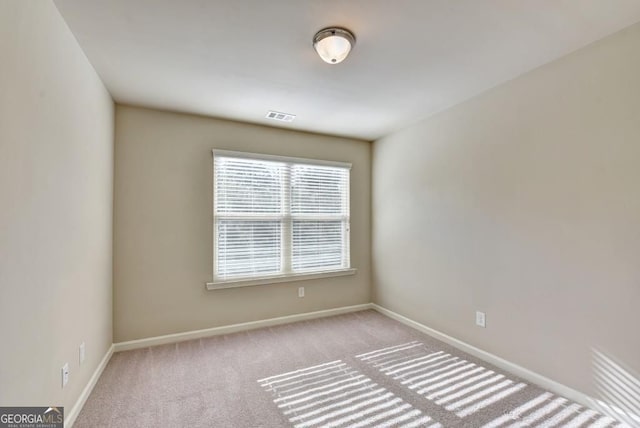 spare room with visible vents, baseboards, and carpet flooring