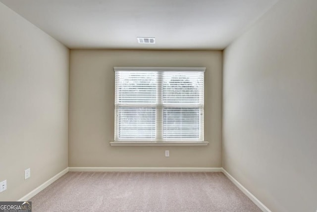 unfurnished room featuring visible vents, baseboards, and carpet