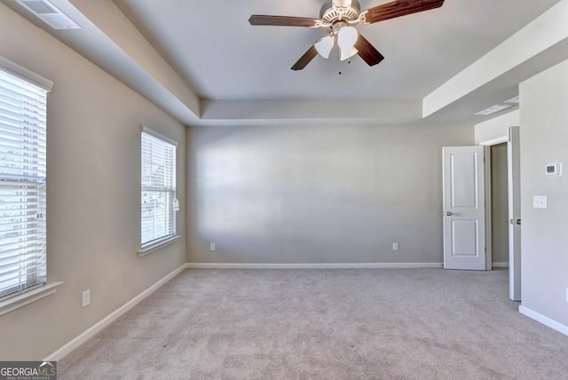 unfurnished room featuring light carpet, visible vents, a ceiling fan, and baseboards