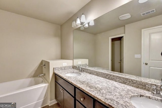 bathroom with a sink, visible vents, double vanity, and a washtub