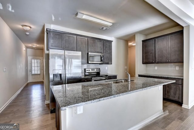 3082 Cedar Glade Ln NE, Buford, GA 30519 - kitchen with appliances with stainless steel finishes, a sink, dark brown cabinetry, and tasteful backsplash