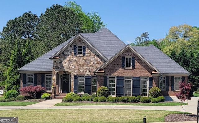 view of front of property with brick siding, stone siding, and a front yard