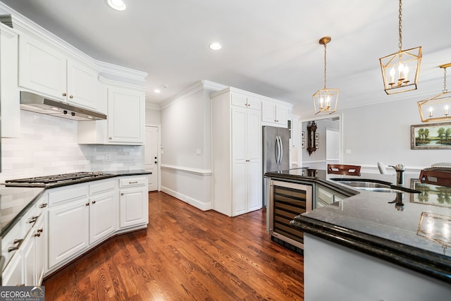 kitchen featuring a sink, under cabinet range hood, white cabinetry, stainless steel appliances, and beverage cooler