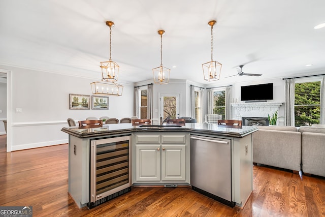 kitchen featuring open floor plan, wine cooler, ceiling fan, dishwasher, and a sink