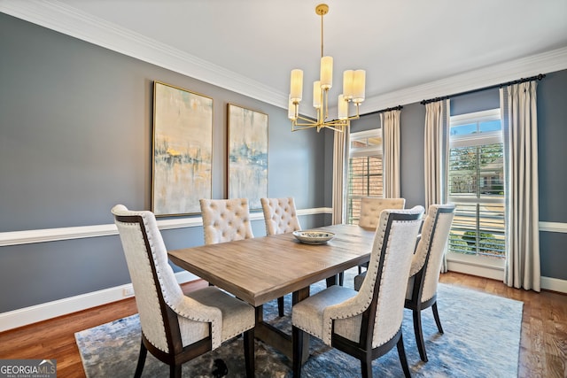 dining space featuring a chandelier, wood finished floors, baseboards, and ornamental molding