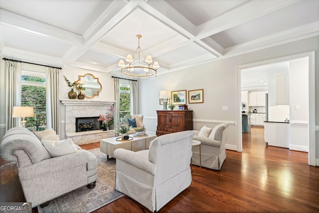 living room featuring an inviting chandelier, a fireplace, dark wood-style flooring, coffered ceiling, and beam ceiling