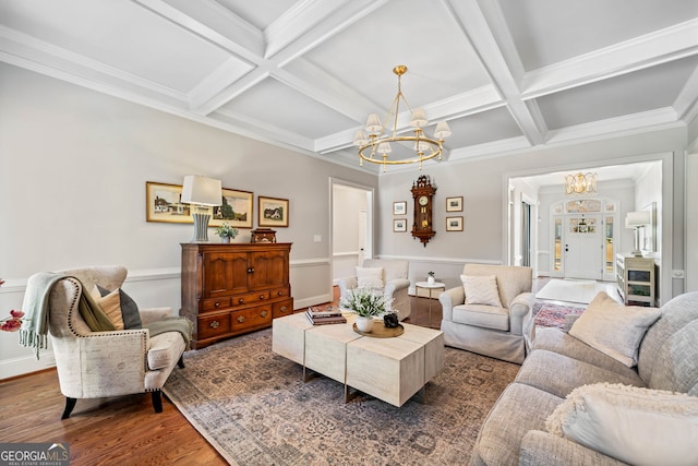 living area with coffered ceiling, crown molding, wood finished floors, and a notable chandelier