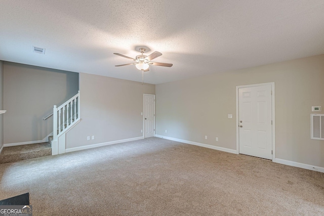 spare room with baseboards, carpet flooring, visible vents, ceiling fan, and stairway