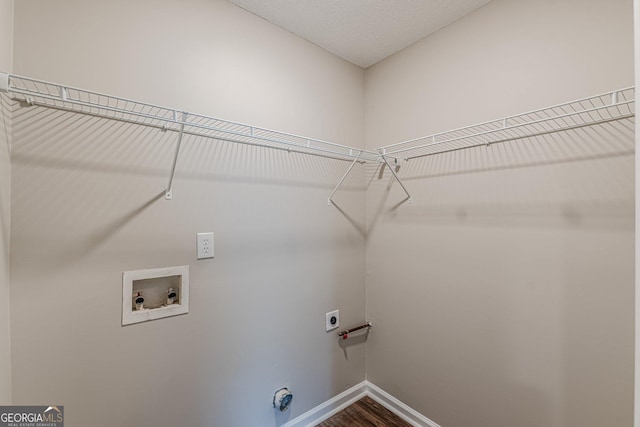 laundry room featuring electric dryer hookup, laundry area, washer hookup, dark wood-type flooring, and baseboards