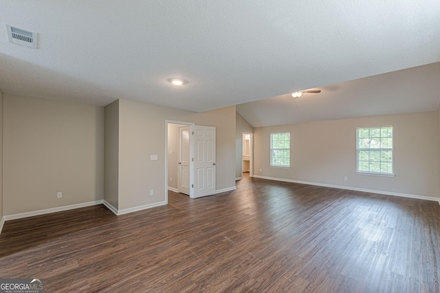 unfurnished room featuring a textured ceiling, baseboards, dark wood-style floors, and visible vents