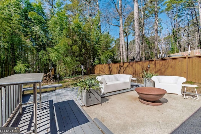 view of patio with fence, a deck, and view of scattered trees