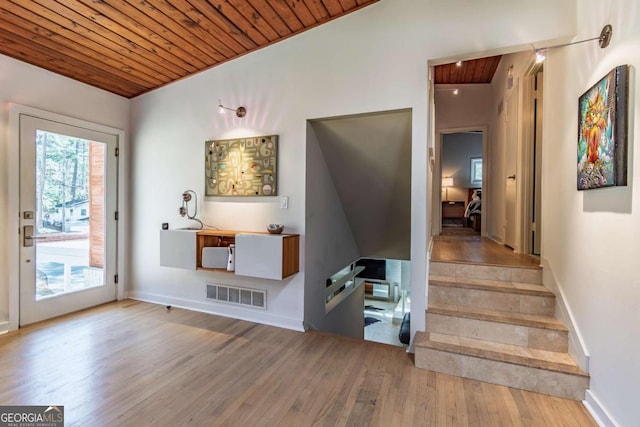 interior space with wooden ceiling, wood finished floors, baseboards, and stairway