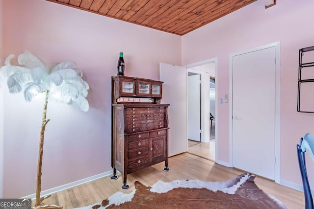 bedroom with wood ceiling, wood finished floors, and baseboards
