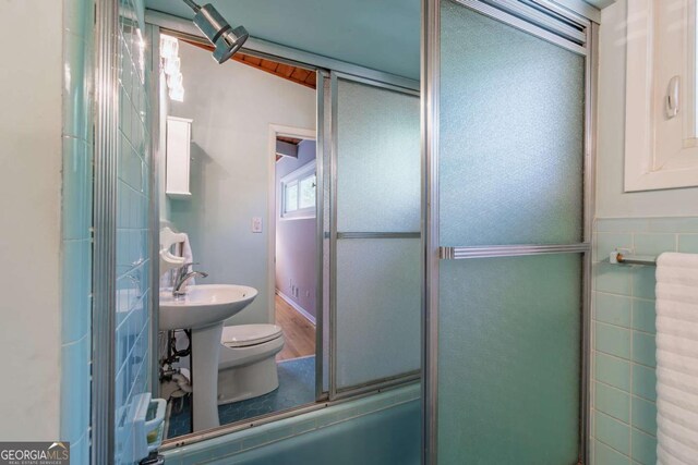 full bathroom with toilet and a shower with door