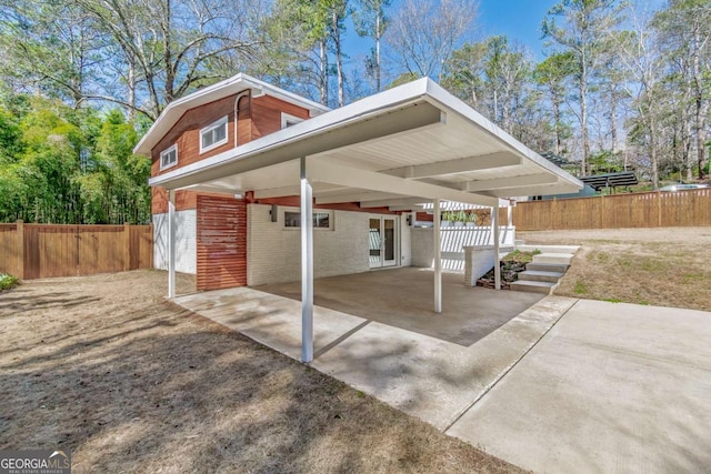 view of patio / terrace featuring a carport, fence, and driveway