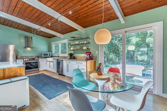 kitchen featuring appliances with stainless steel finishes, wall chimney exhaust hood, light wood-style floors, white cabinets, and wooden ceiling