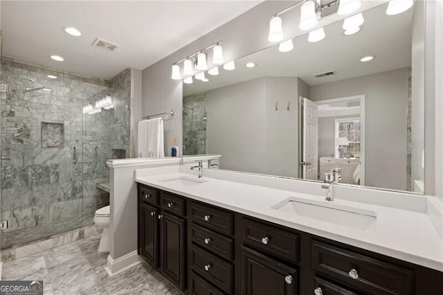 bathroom featuring a stall shower, toilet, visible vents, and a sink