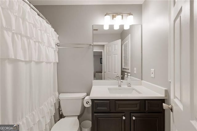 bathroom with a shower with shower curtain, toilet, and vanity