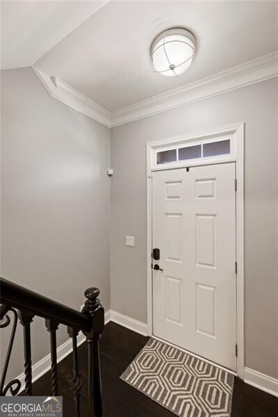 entrance foyer with baseboards, dark wood-style floors, and crown molding