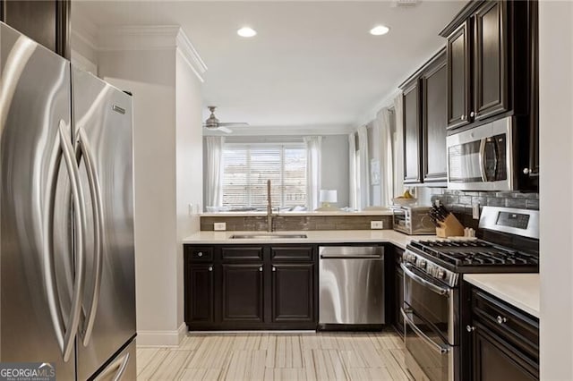 kitchen featuring a ceiling fan, a sink, light countertops, appliances with stainless steel finishes, and tasteful backsplash