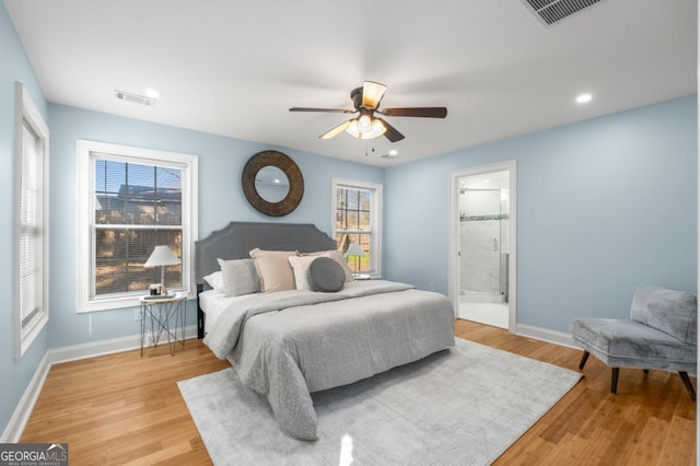 bedroom with ceiling fan, wood finished floors, visible vents, and baseboards