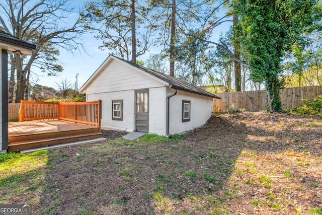 back of property featuring a deck, fence, and stucco siding