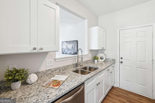 kitchen featuring dark wood-style floors, white cabinets, light stone countertops, and a sink