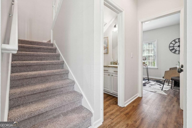 staircase featuring baseboards and wood finished floors